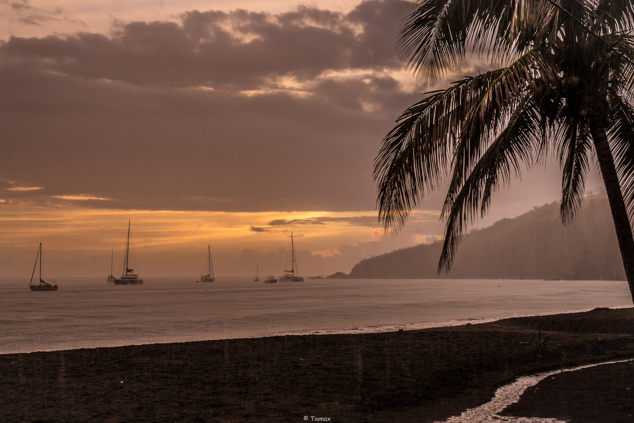 Plage de Malendure Bouillante Guadeloupe - sable noir volcanique et bateaux de plongee